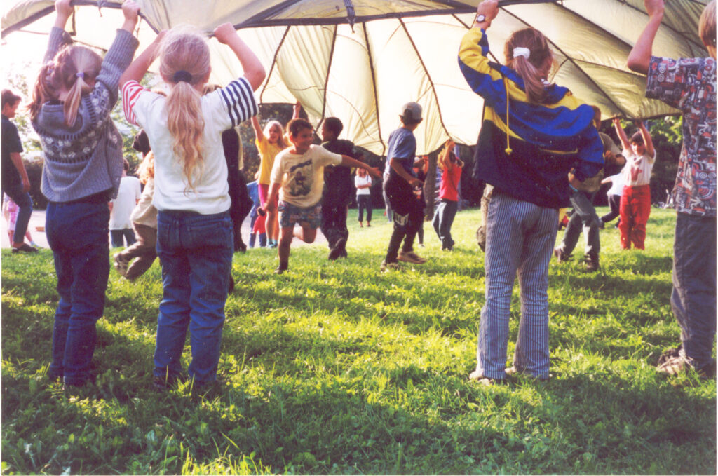 Foto: Kinder beim 'Fallschirmspiel' unter echten Fallschirmen